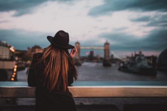girl on bridge wearing a black hat